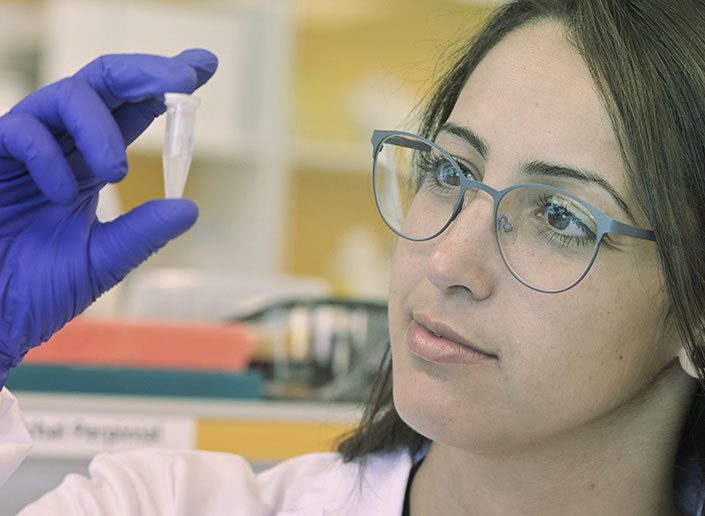 compugen employee in lab with vial